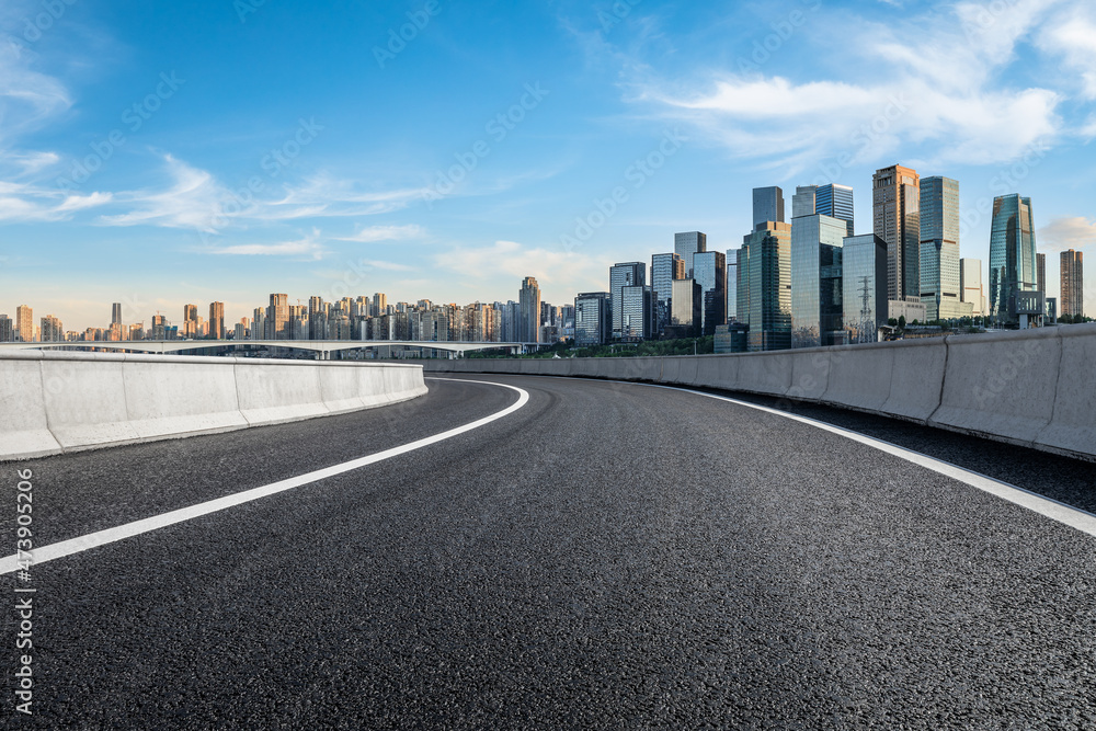 全景天际线和现代商业办公楼，道路空旷。沥青路和城市景观