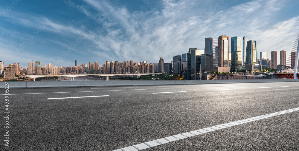 全景天际线和现代商业办公楼，道路空旷。沥青路和城市景观