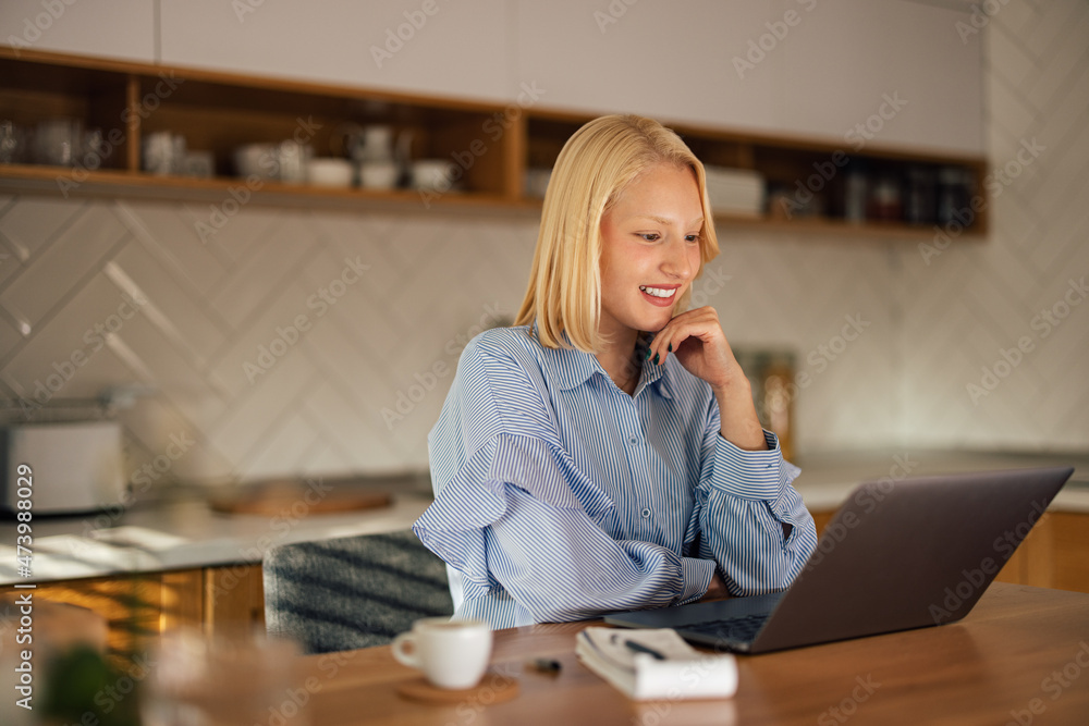 Happy young employee, checking her colleagues document on her laptop.