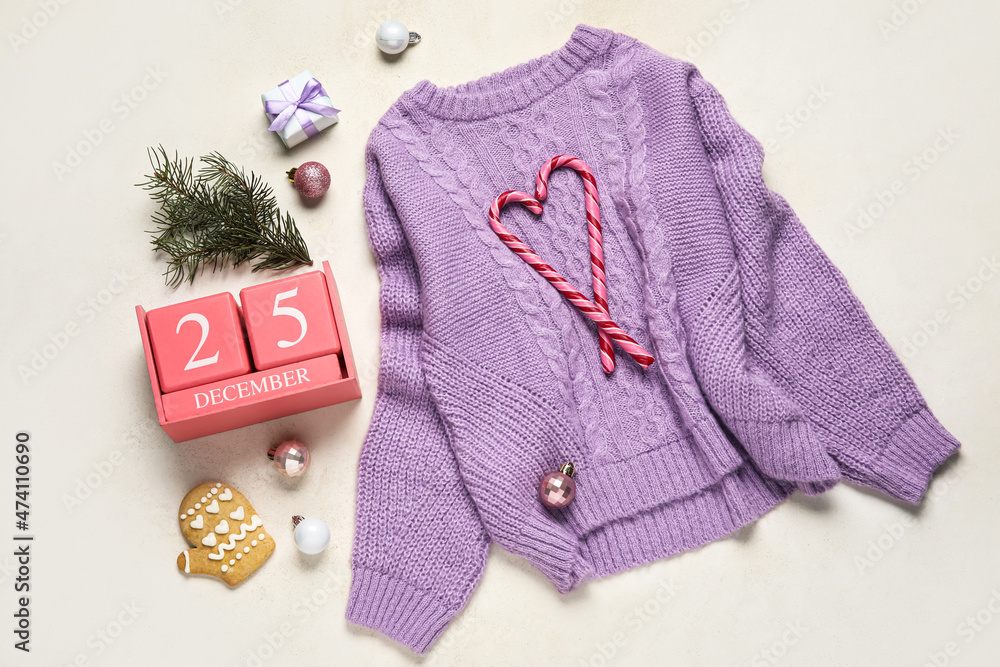 Warm sweater, calendar and Christmas decor on light background