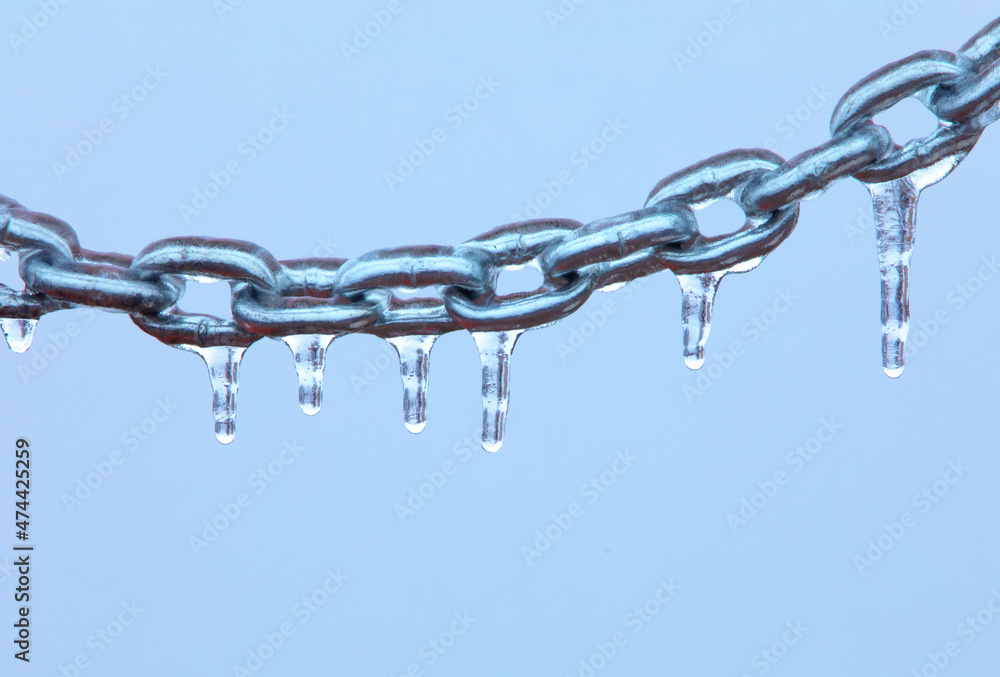 Icicles on a chain, frosted metal on a light background.