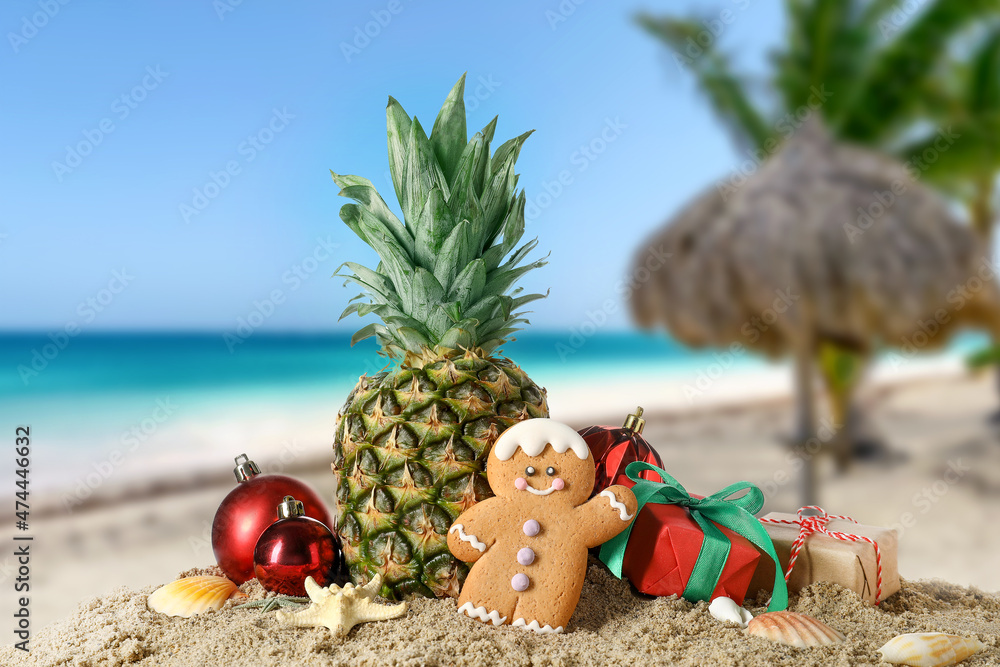 Christmas composition with pineapple on sand at tropical resort