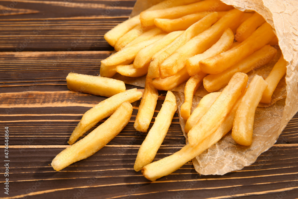 Tasty french fries on wooden table