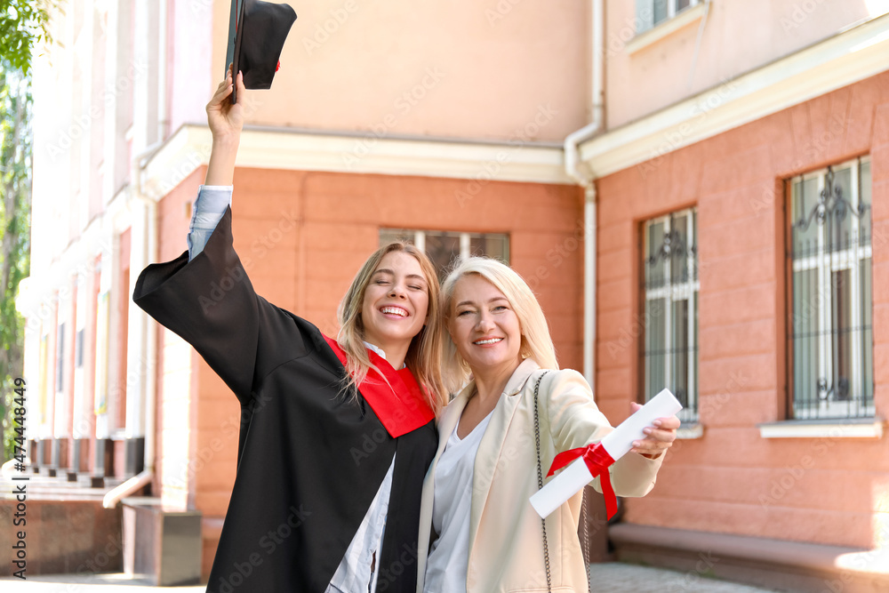 Happy young woman with her mother on graduation day