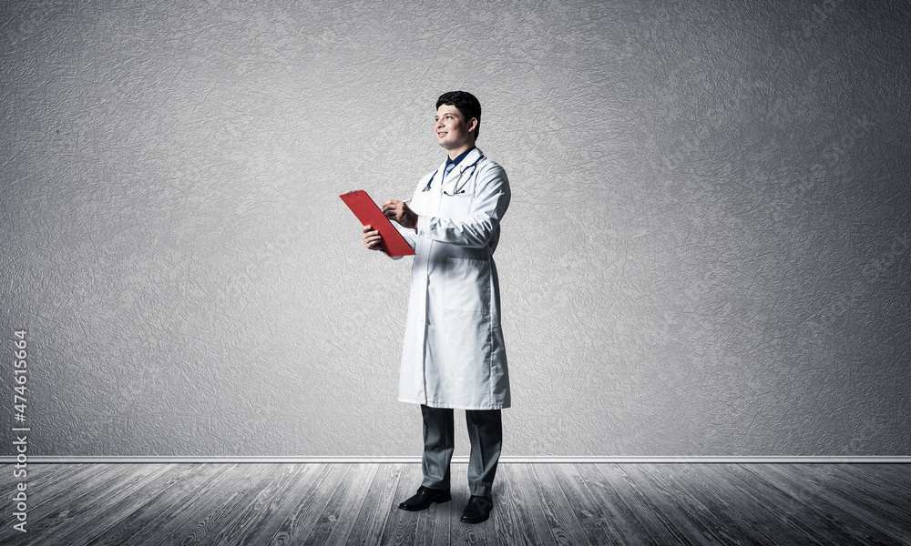 The doctor holds a red tablet for documents in front of him