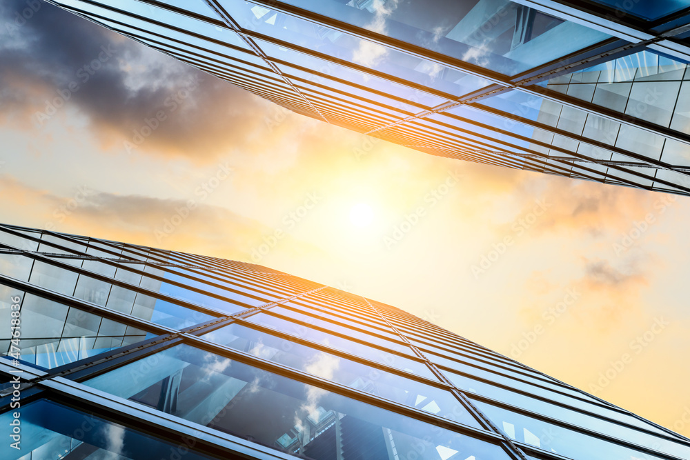 Modern office building with glass facade on a clear sky background. Transparent glass wall of office