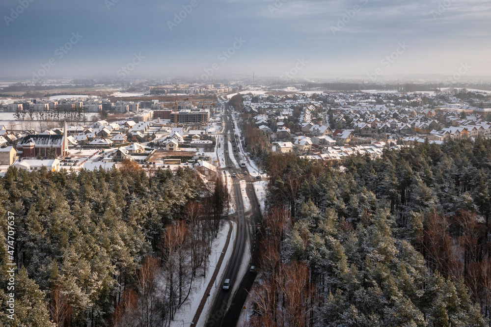 波兰冬季穿过雪地森林的公路空中景观。