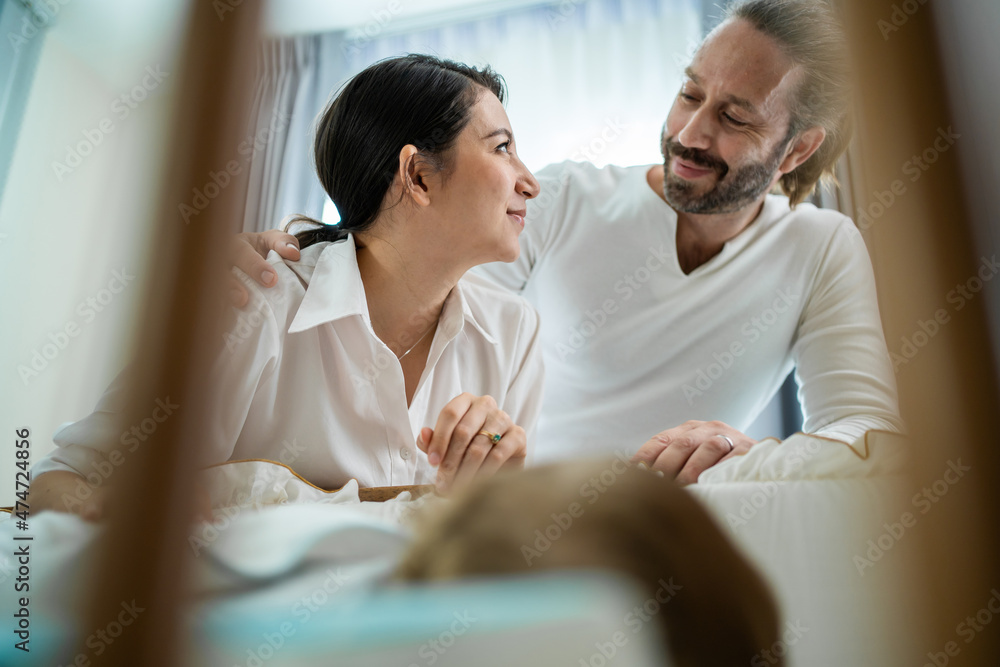 高加索父母在家里的卧室里照顾熟睡的男婴。