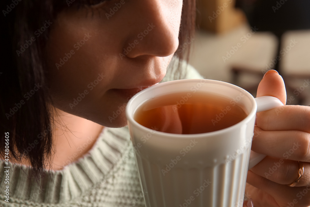 女人在咖啡馆喝可口的茶，特写