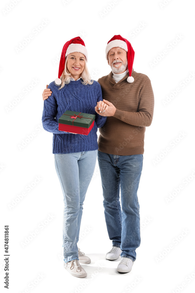 Happy mature couple with Christmas gift on white background