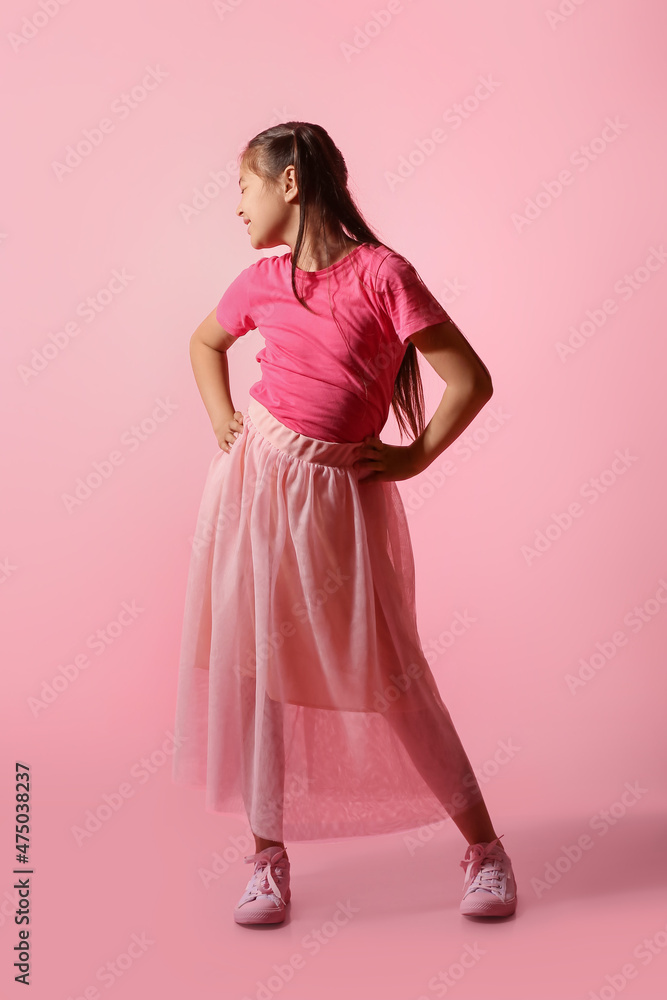 Dancing little girl on color background