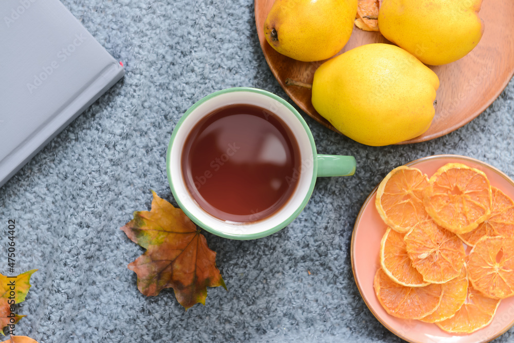 灰色织物背景上的绿茶、落叶和食物