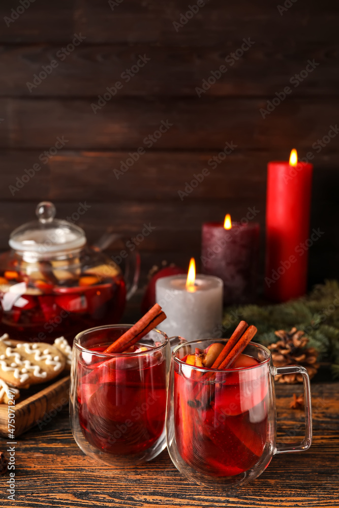 Glass cups of tasty fruit tea with cinnamon on wooden background