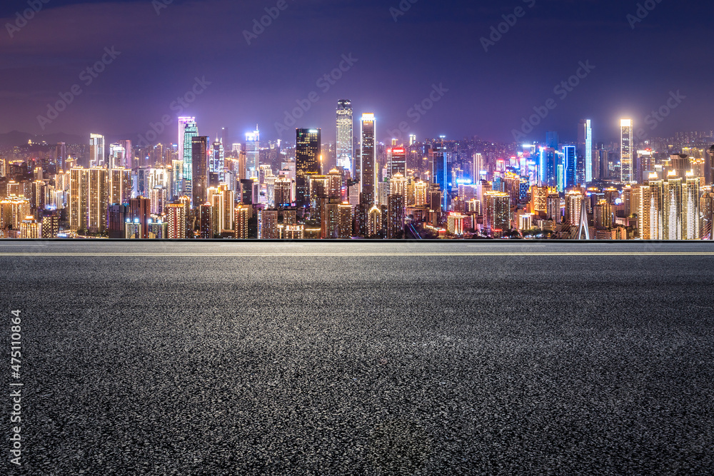 全景天际线和空荡荡的现代商业建筑。夜晚的沥青道路和城市景观