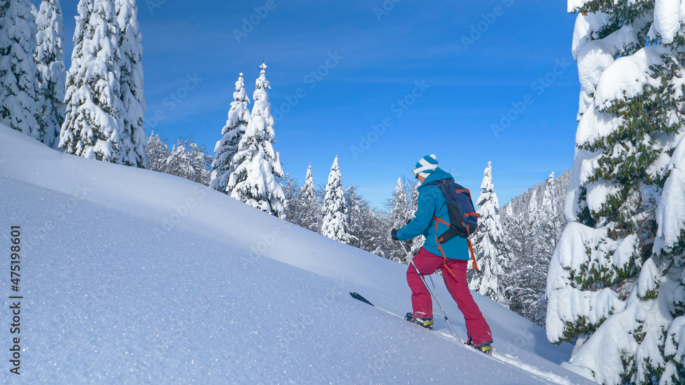 复制空间：Bohinj的一名女子在新雪覆盖下徒步上山。