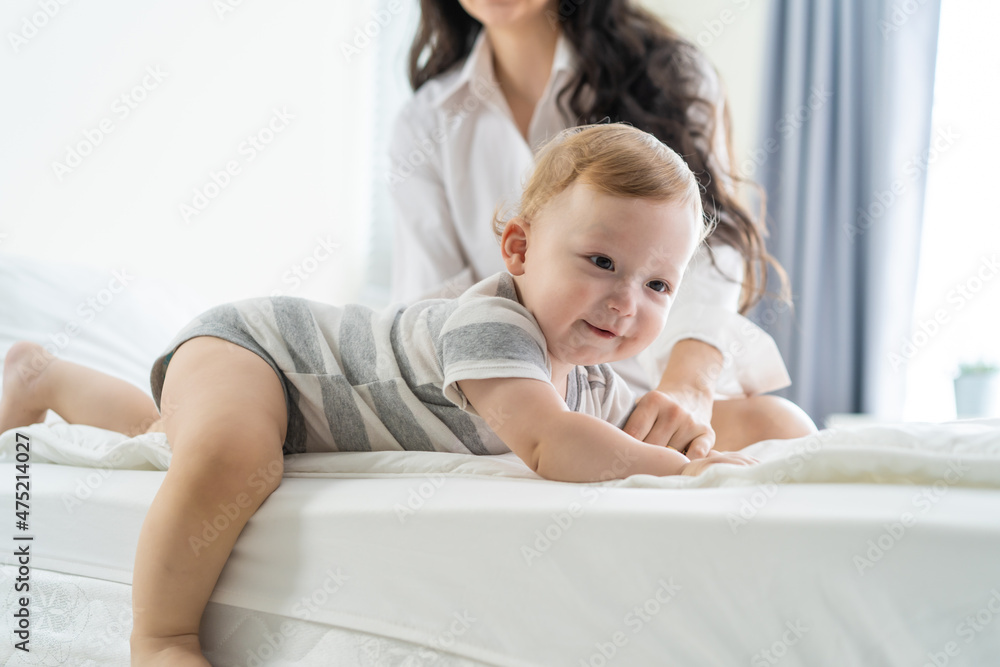 高加索父母在卧室的床上和可爱的男婴玩耍。