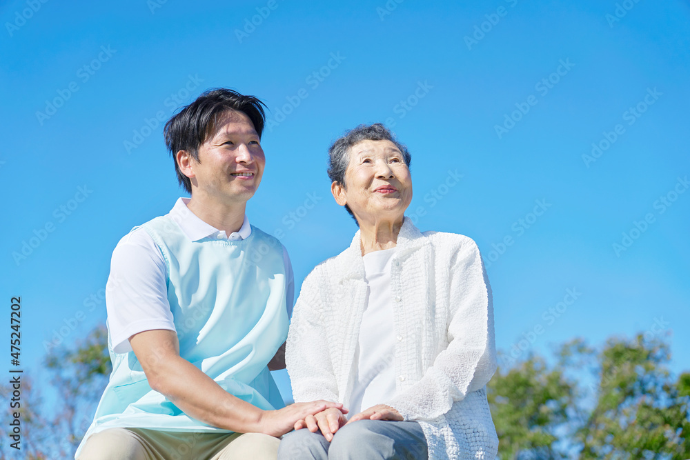 介護士と高齢者　屋外