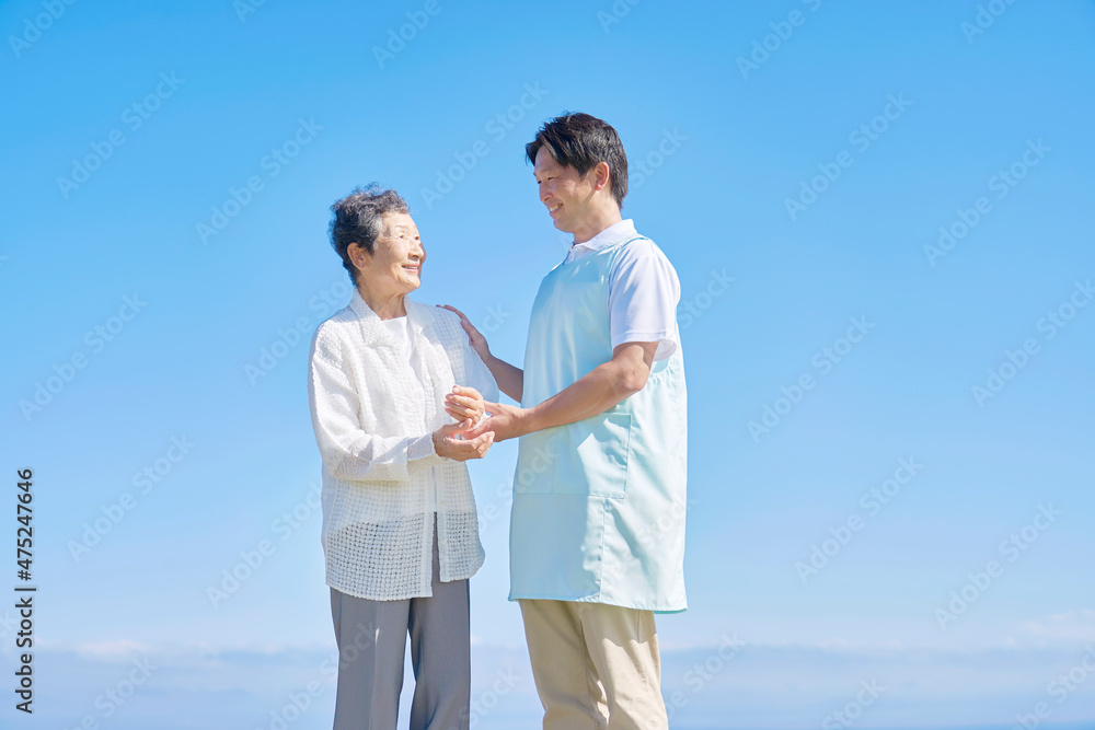 介護士と高齢者　屋外