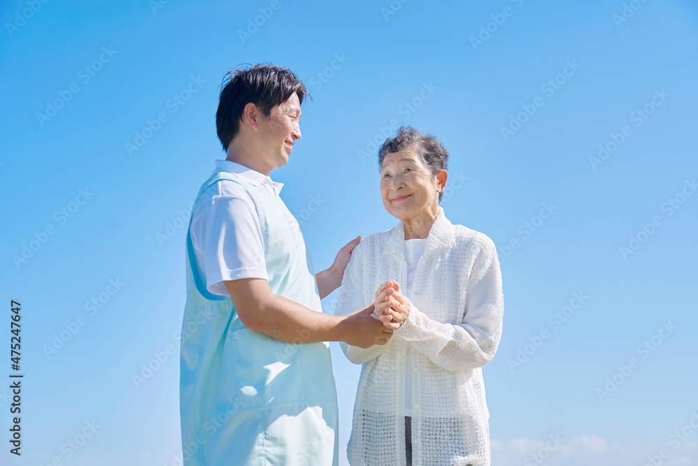 介護士と高齢者　屋外