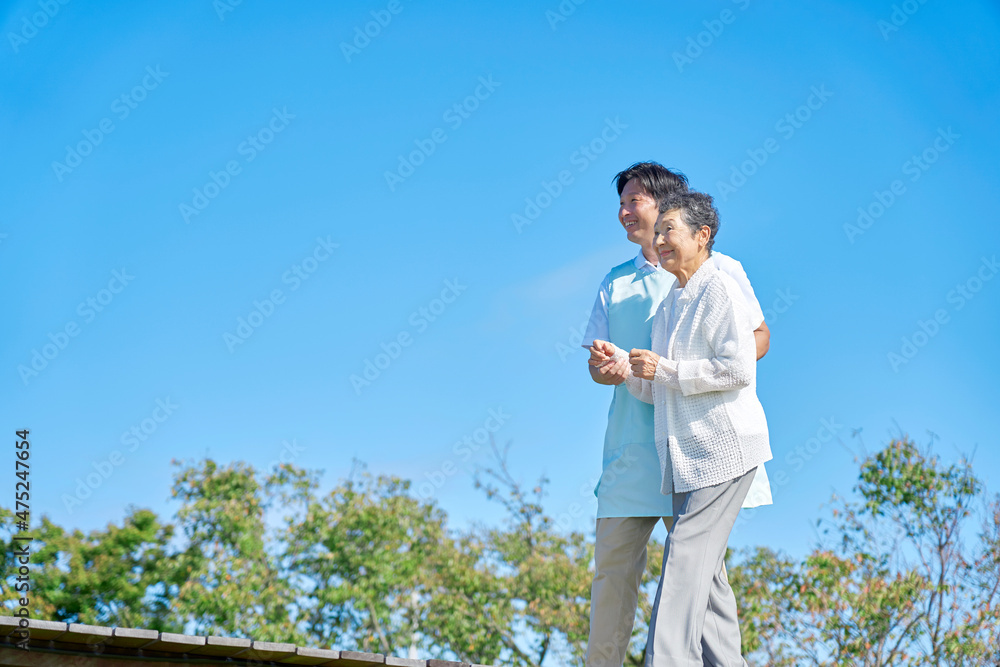 介護士と高齢者　屋外