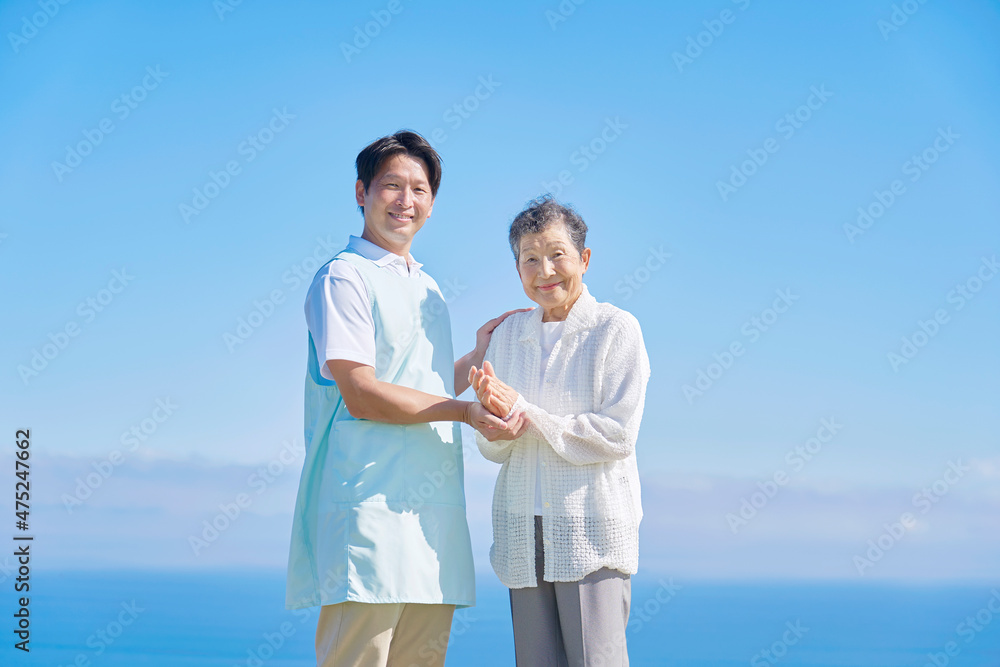 介護士と高齢者　屋外