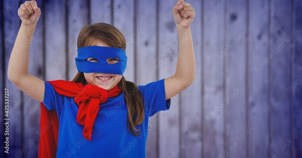 Composite image of caucasian girl in superhero costume against blue textured background