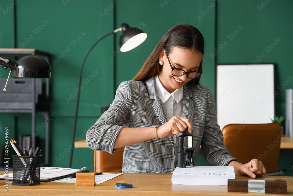 女性公证人在办公文件上盖章