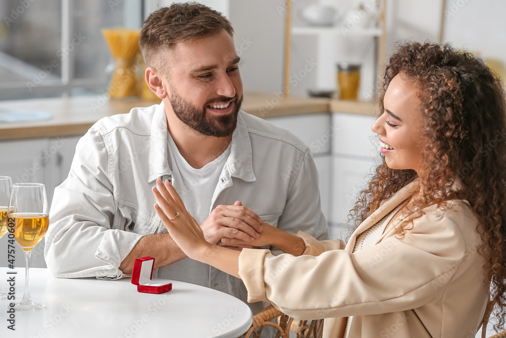 Happy young engaged couple at home