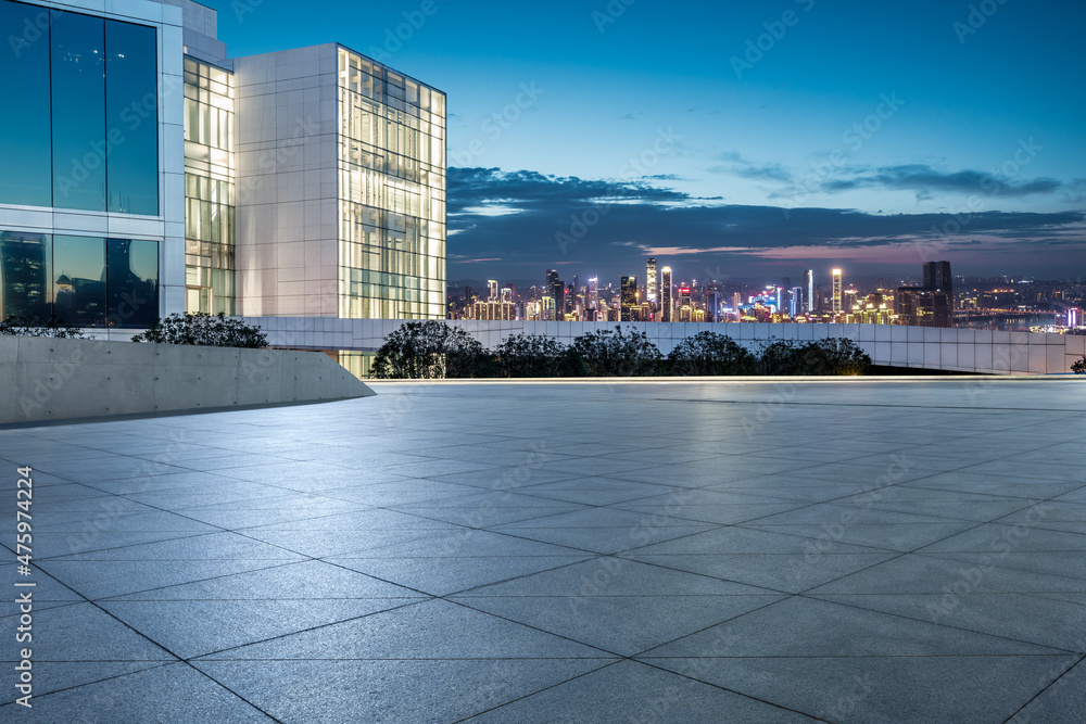 Panoramic skyline and modern commercial buildings with empty square at night