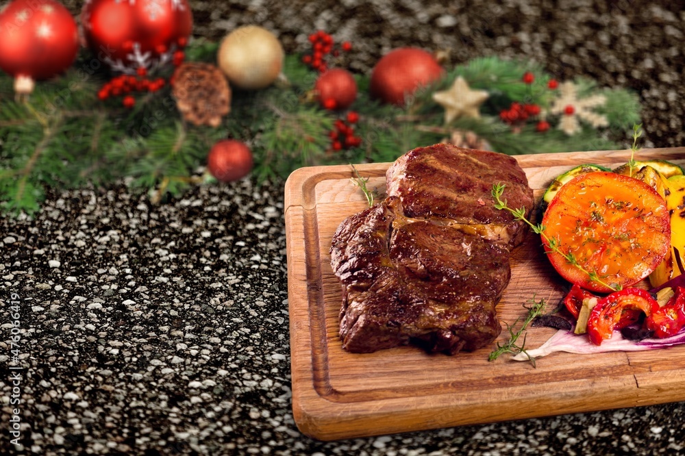 Christmas dinner for two. Baked beef with spices with Christmas tree decorations