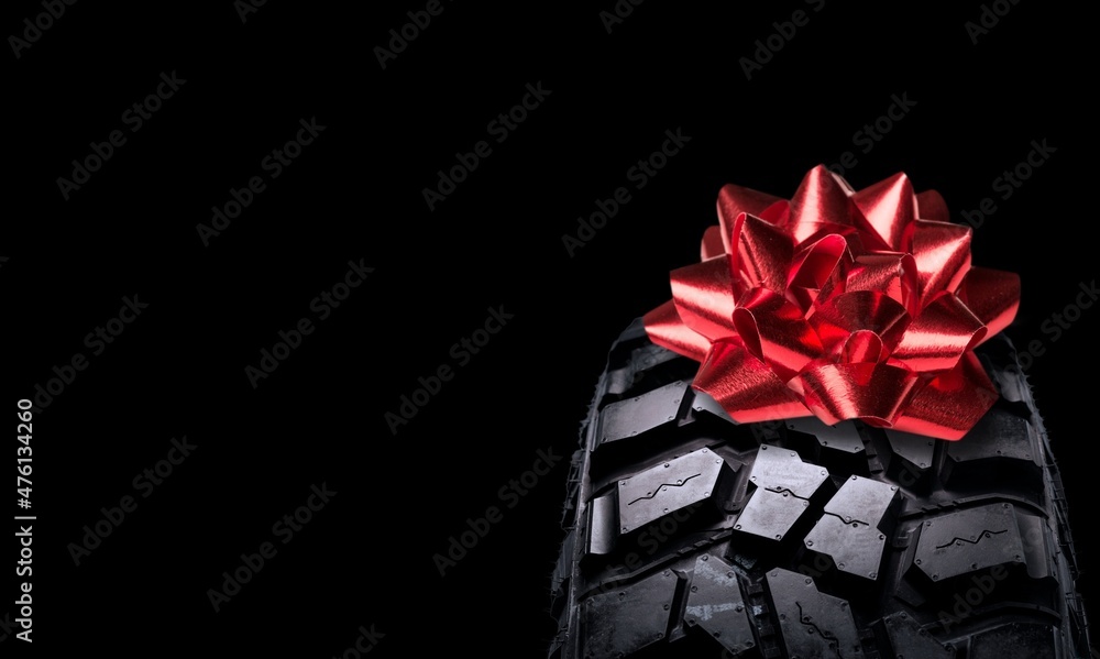 Classic black rubber tire, on the backgrounds in a bow for christmas