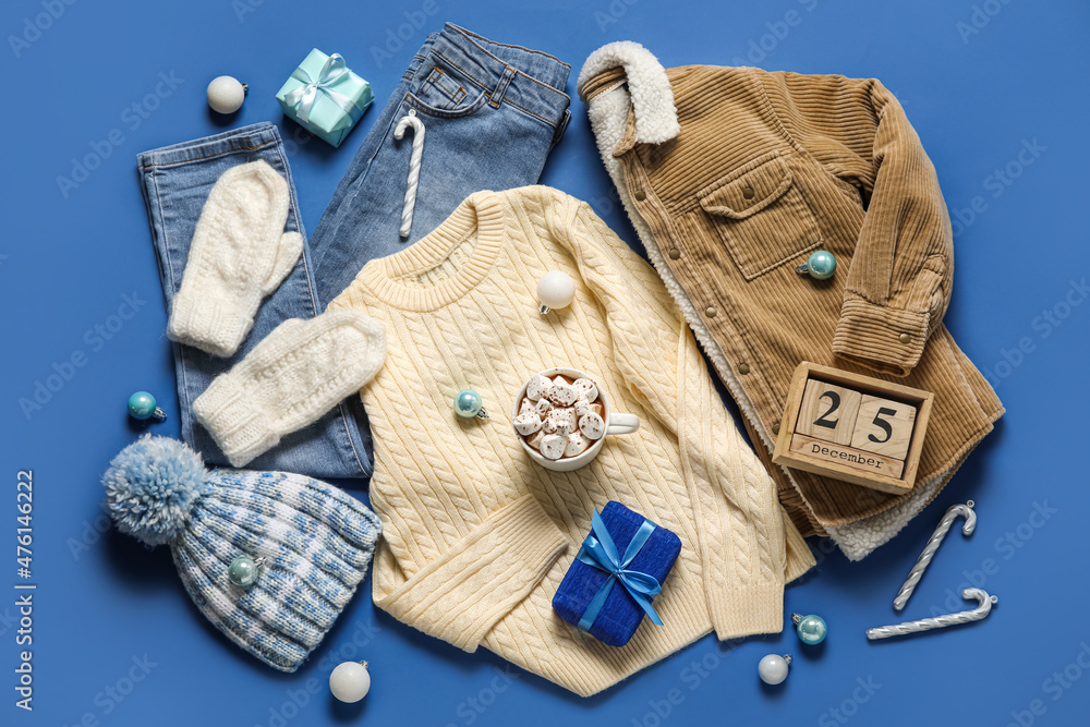 Set of childrens clothes, cup of hot chocolate and calendar with date of Christmas on color backgro