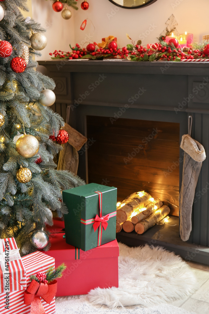 Christmas tree with gifts near fireplace in living room