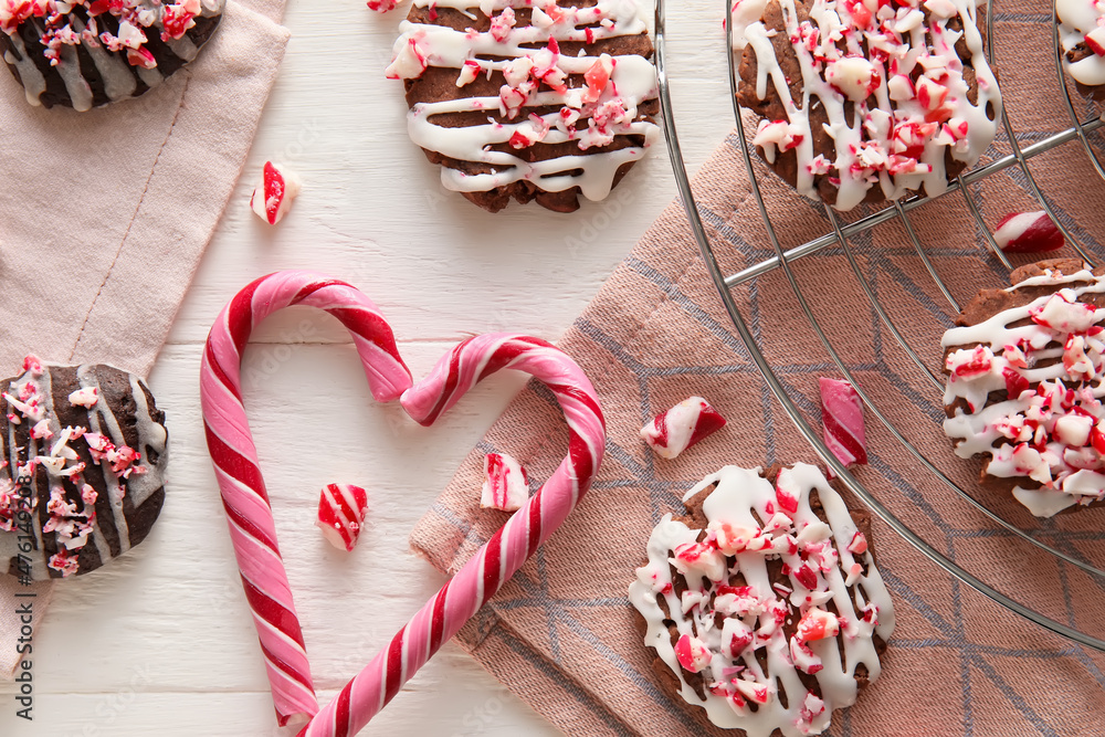 Grid with tasty candy cane cookies on white wooden background