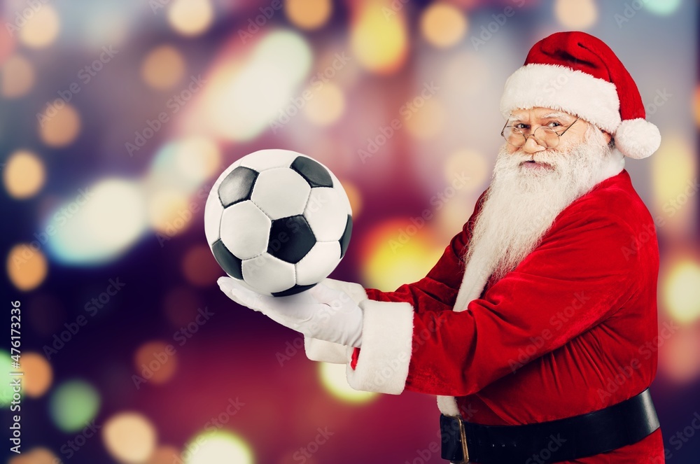 Portrait of attractive cheerful fat white-haired Santa holding in hands soccer ball having fun