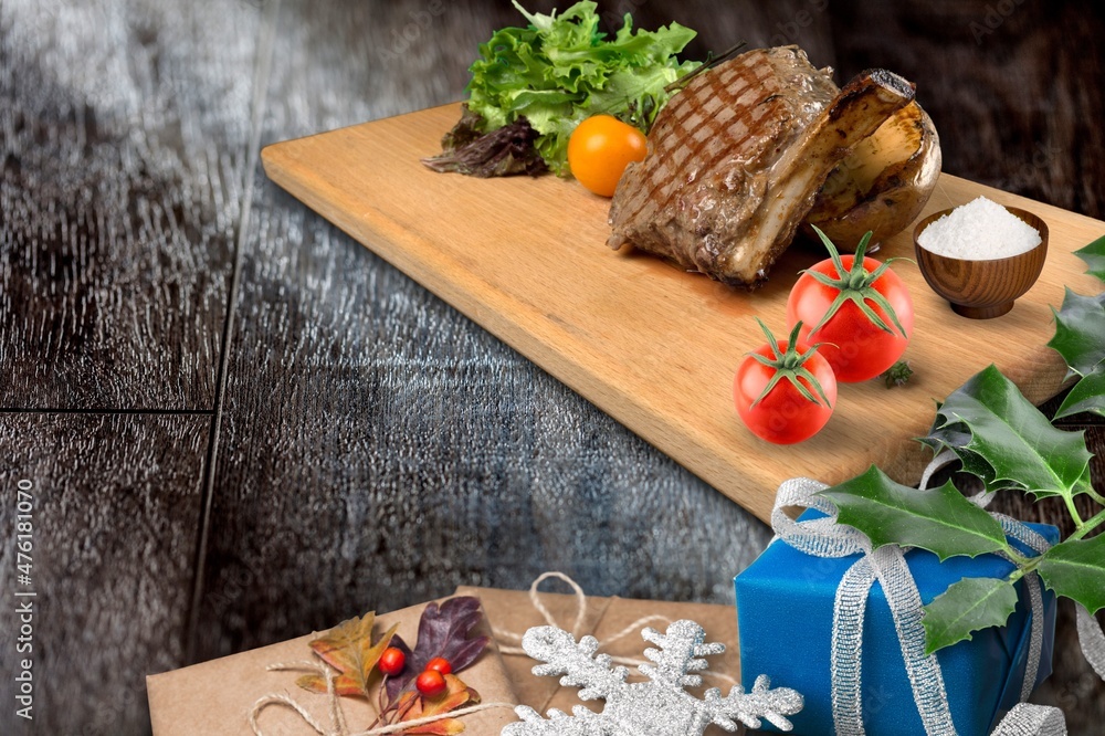 Christmas dinner for two, grilled beef steak, ribeye, greens and spices with a Christmas tree