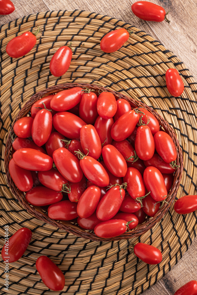 Fresh cherry tomatoes over wooden table background.