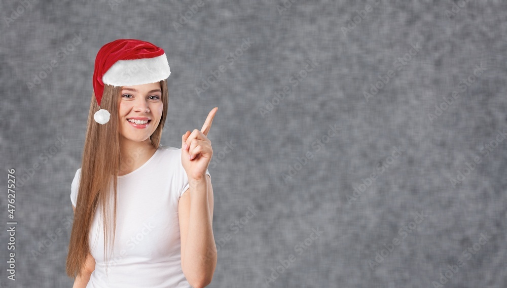 Happy smiling attractive young woman pointing and opening palms at blank space