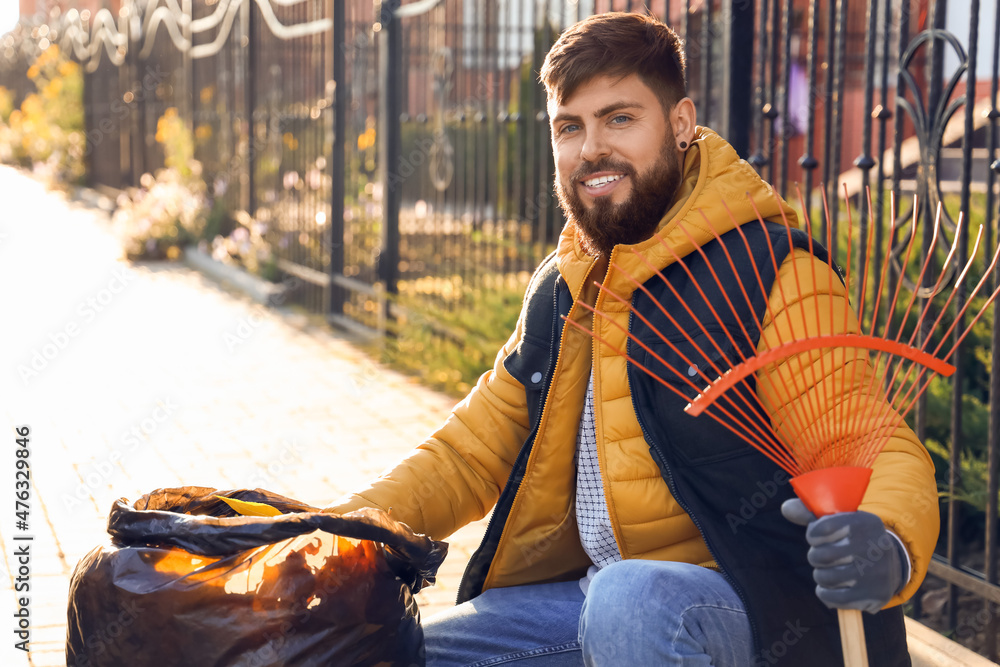 Man gathering autumn leaves outdoors