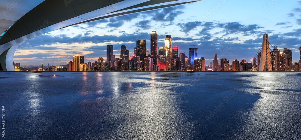 Panoramic skyline and modern commercial buildings with empty road. Asphalt road and cityscape at nig