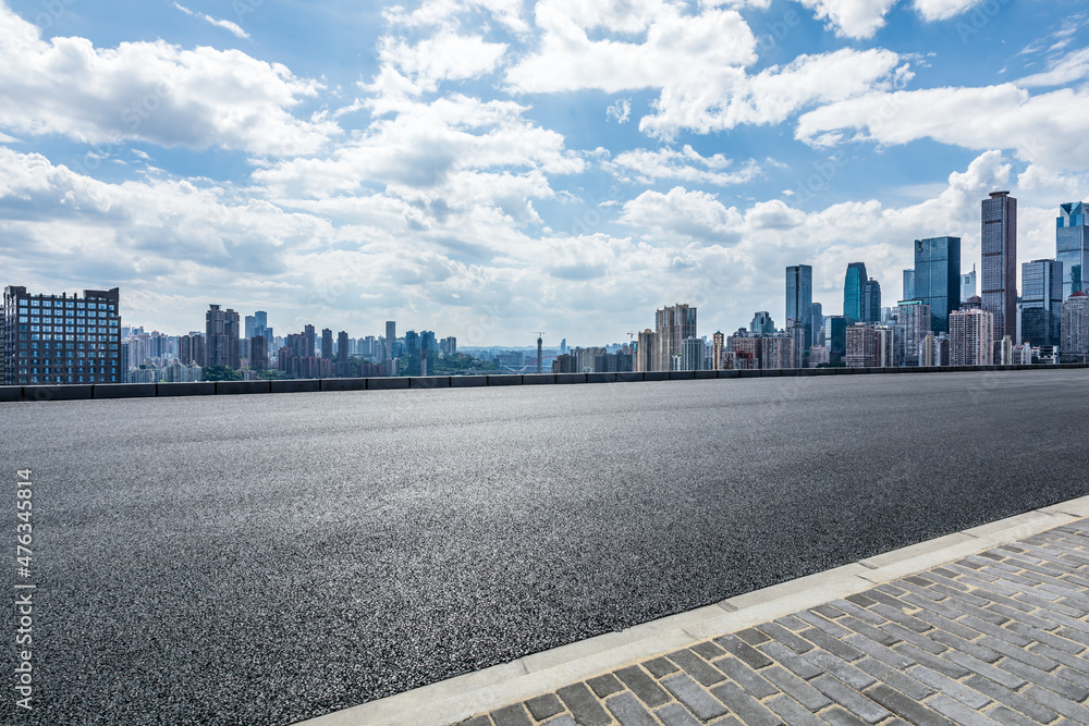 空荡荡的柏油路和拥有现代商业建筑的城市天际线