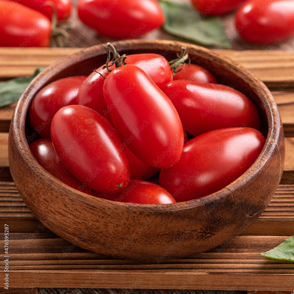 Fresh cherry tomatoes in a basket with spices.