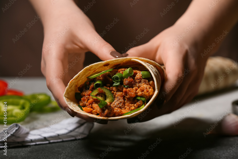 桌子上拿着美味卷饼的女人，特写