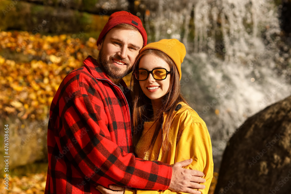 Portrait of happy loving couple near waterfall