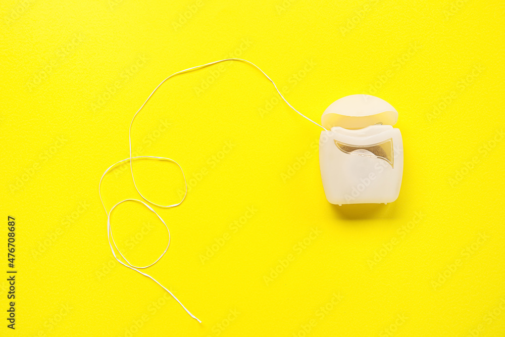 Dental floss on yellow background