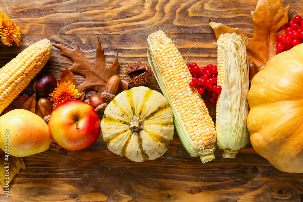 Different healthy food with autumn leaves and acorns on wooden background. Harvest festival