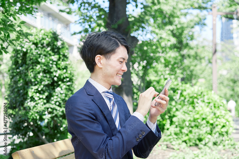 ビジネスマン　スマホ　屋外