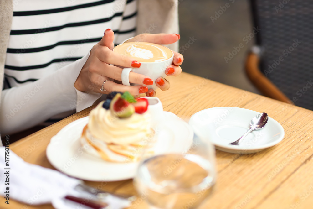 修指甲很漂亮的年轻女人在咖啡馆拿着一杯咖啡，特写