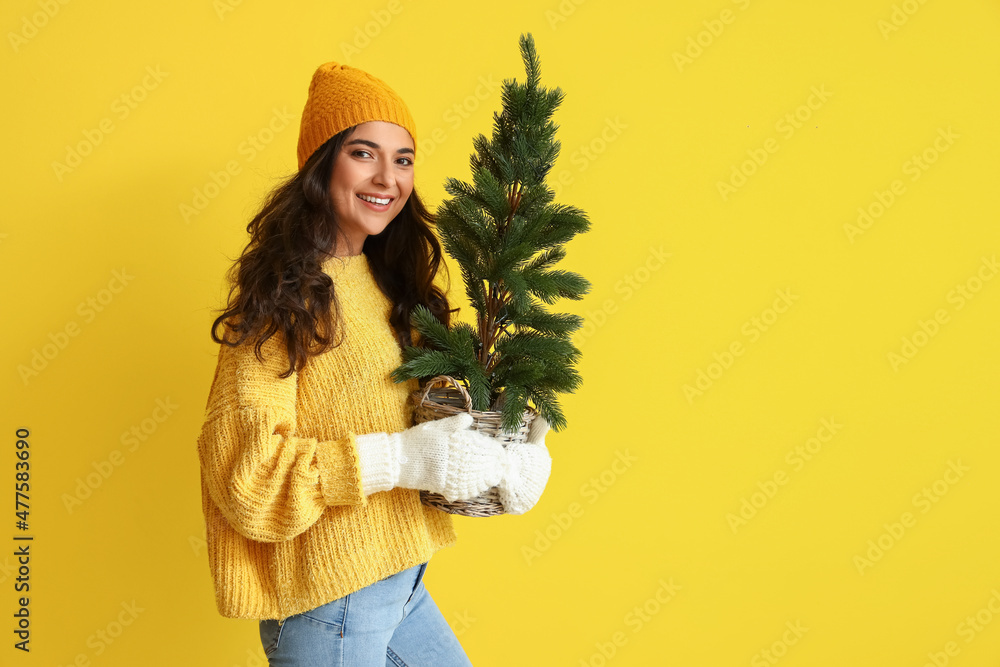 穿着冬装，背景是圣诞树的漂亮年轻女人