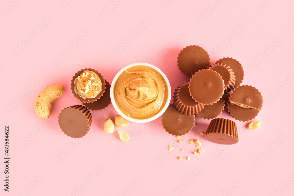 Tasty peanut butter cups on color background